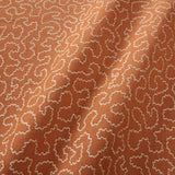 A woven fabric sample in orange and off-white featuring a wavy pattern.
