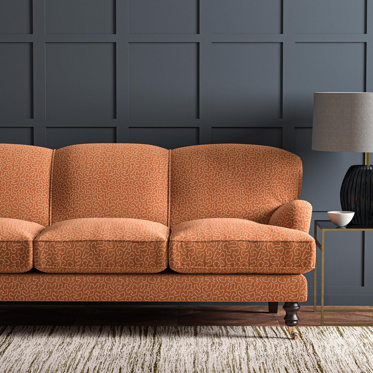 Sofa upholstered in a orange and off-white woven fabric featuring a wavy pattern.