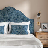 Headboard upholstered in a blue and off-white woven fabric featuring a wavy pattern.