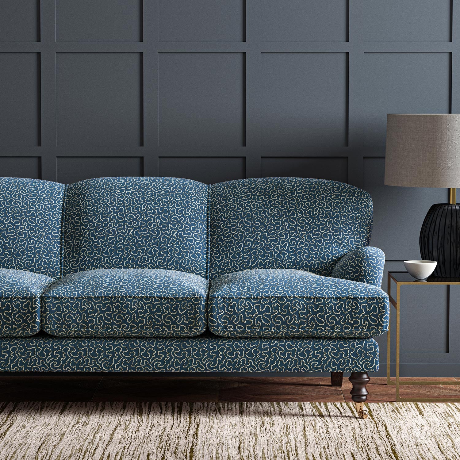 Sofa upholstered in a blue and off-white woven fabric featuring a wavy pattern.
