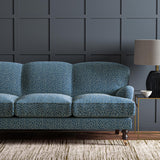 Sofa upholstered in a blue and off-white woven fabric featuring a wavy pattern.