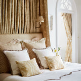 Headboard & cushions upholstered in a yellow and neutral printed linen fabric with a geometric pattern