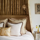 Headboard & cushions upholstered in a yellow and neutral printed linen fabric with a geometric pattern