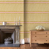 Living room with playful gold and pink wallpaper with a combination of tonal stripes, zigzags, and matching colour bands.