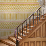 Hall with playful gold and pink wallpaper with a combination of tonal stripes, zigzags, and matching colour bands.