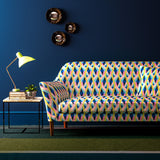 Sofa covered in a velvet upholstery fabric with a bold, geo pattern.