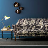 Sofa covered in a printed velvet fabric featuring a rich, tropical-style toile in slate.