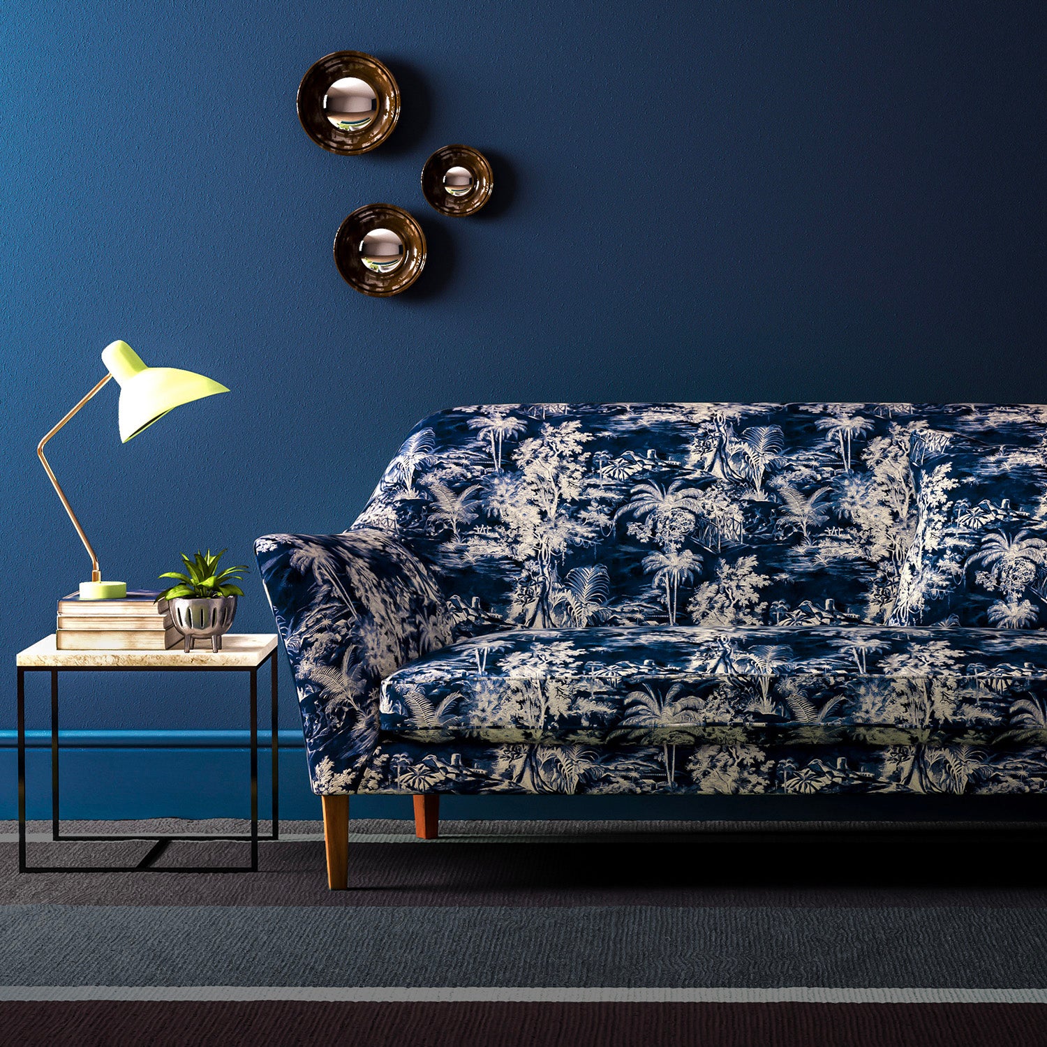 Sofa covered in a printed velvet fabric showcasing a rich, tropical-style toile in Indigo.