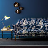 Sofa covered in a printed velvet fabric showcasing a rich, tropical-style toile in Indigo.