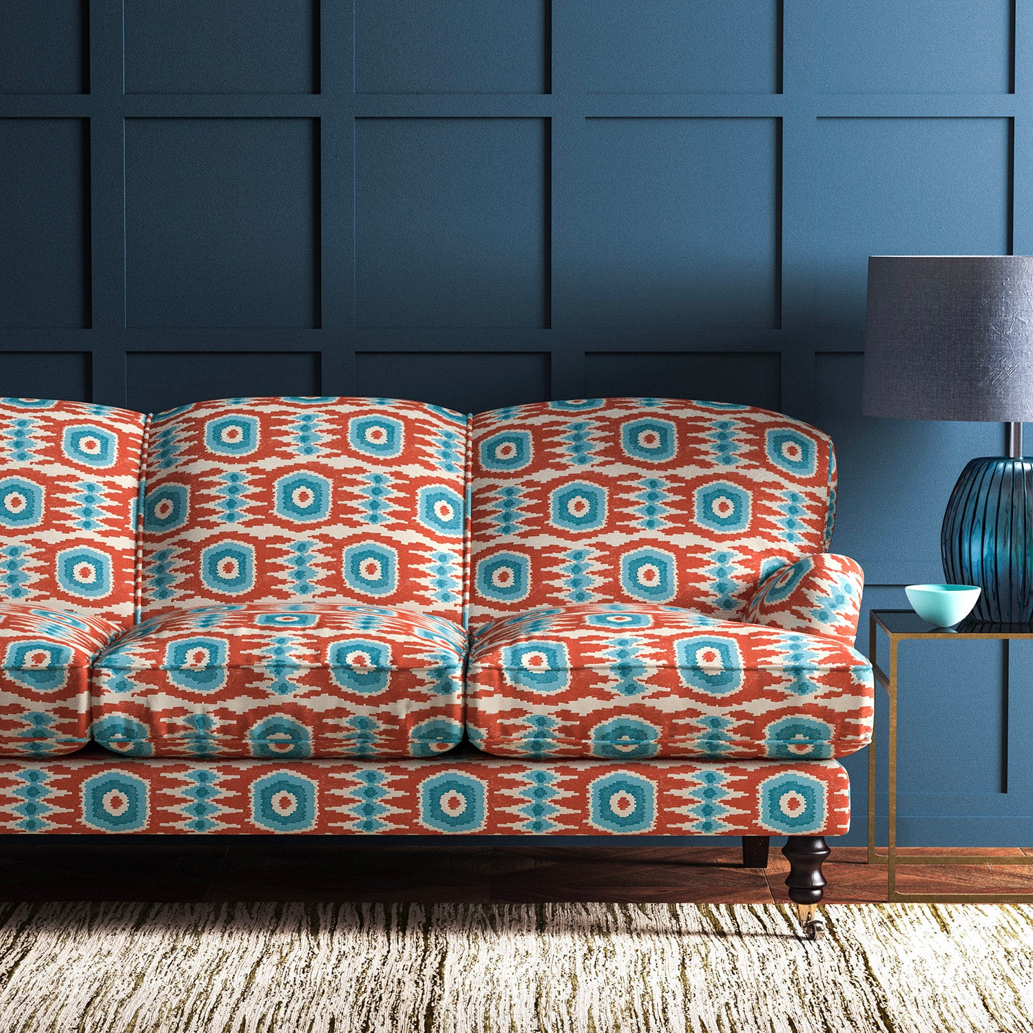 Velvet sofa upholstered in a orange and blue velvet upholstery fabric with abstract print and stain resistant finish