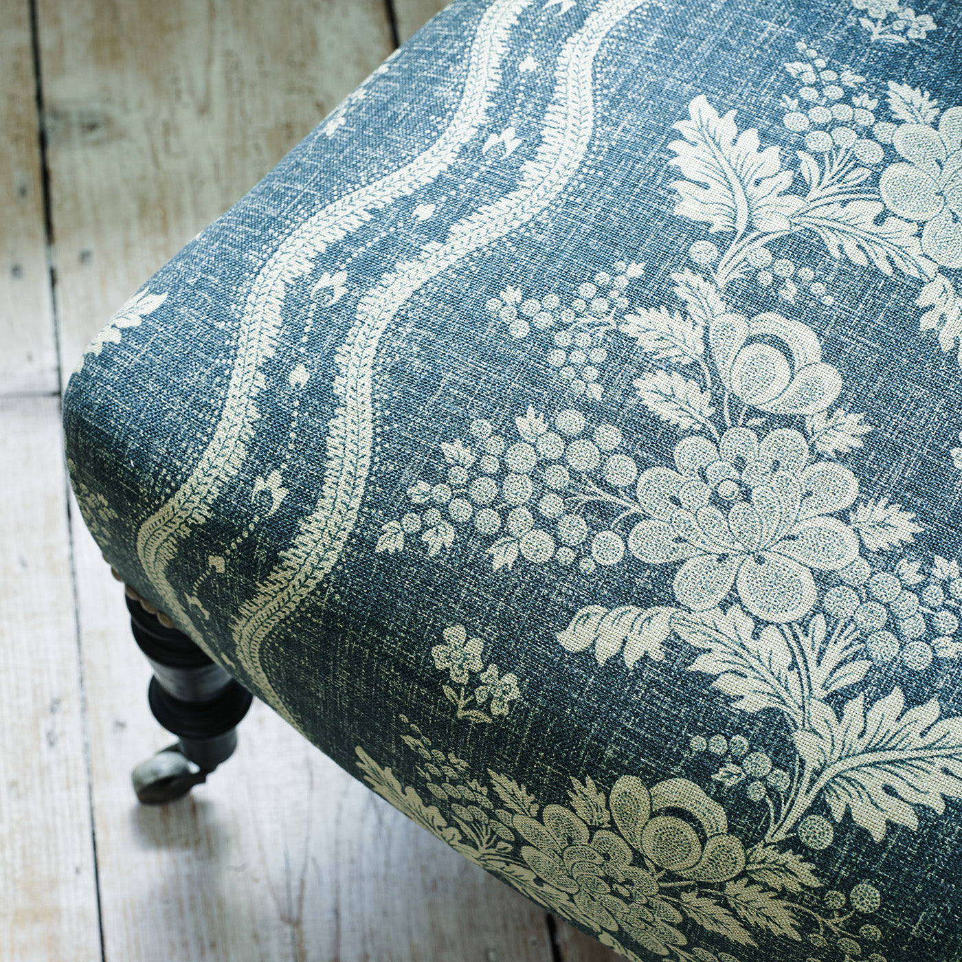 Chair upholstered in a navy floral fabric with stripe design