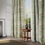 Curtains in a printed linen fabric with floral pattern in blue, green and white colours.
