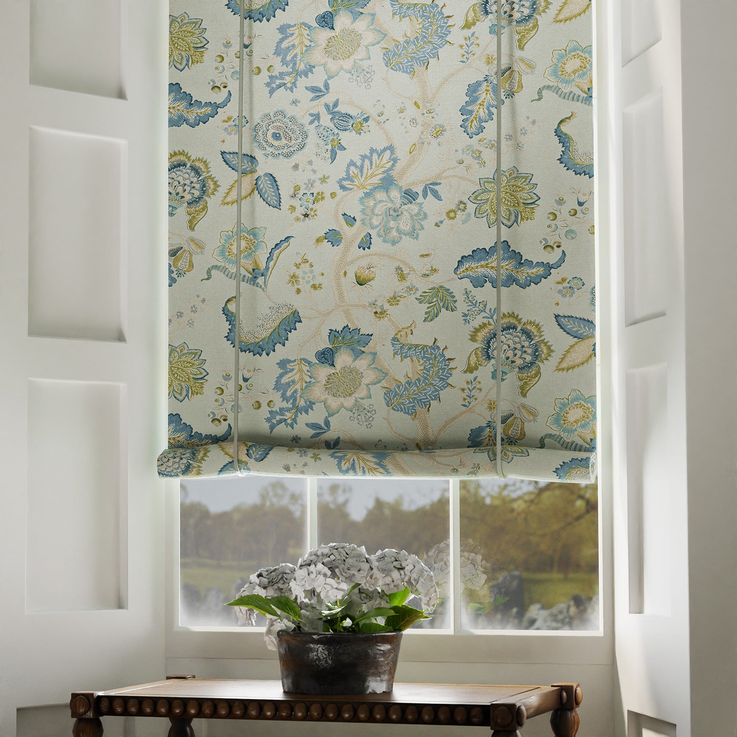 Blind in a printed linen fabric with tree of life design in blue and green colours.