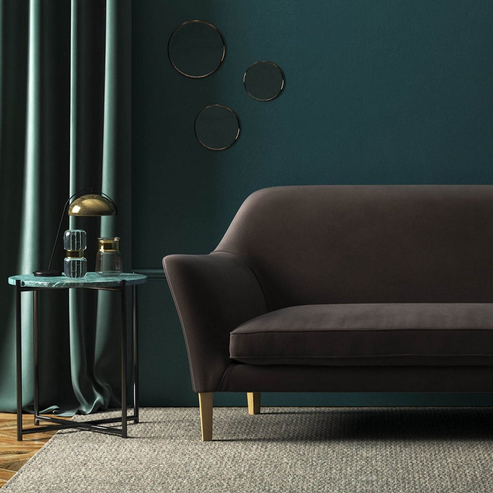 Sofa covered in a brown velvet upholstery fabric