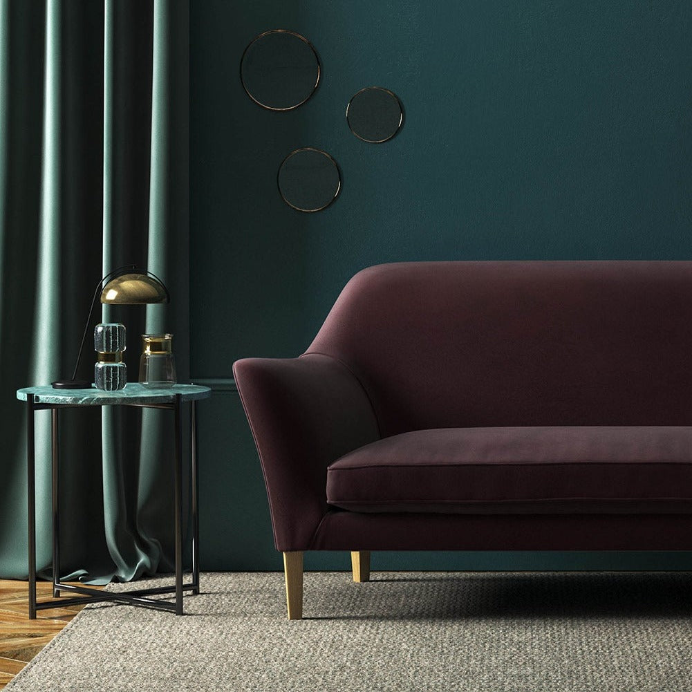 Sofa covered in a purple velvet upholstery fabric