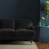 Sofa covered in a black velvet upholstery fabric