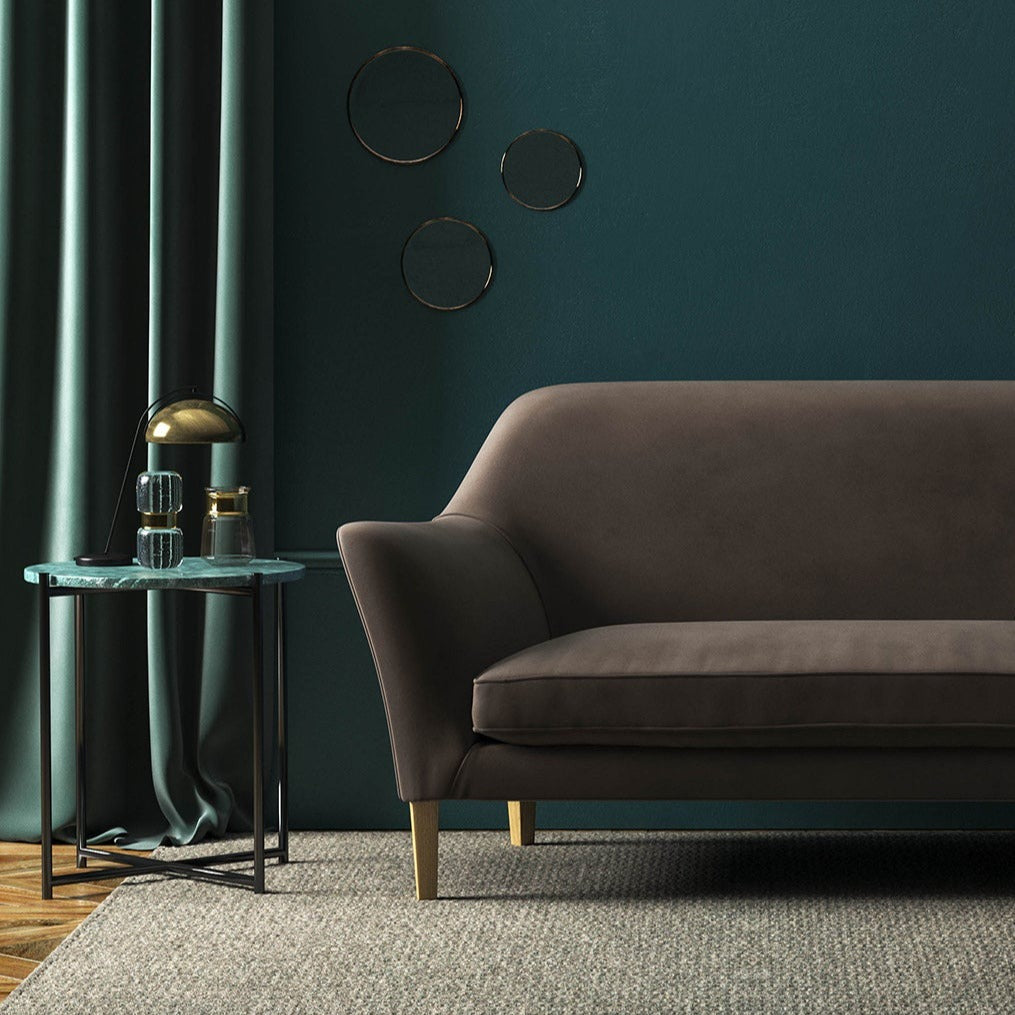 Sofa covered in a brown velvet upholstery fabric