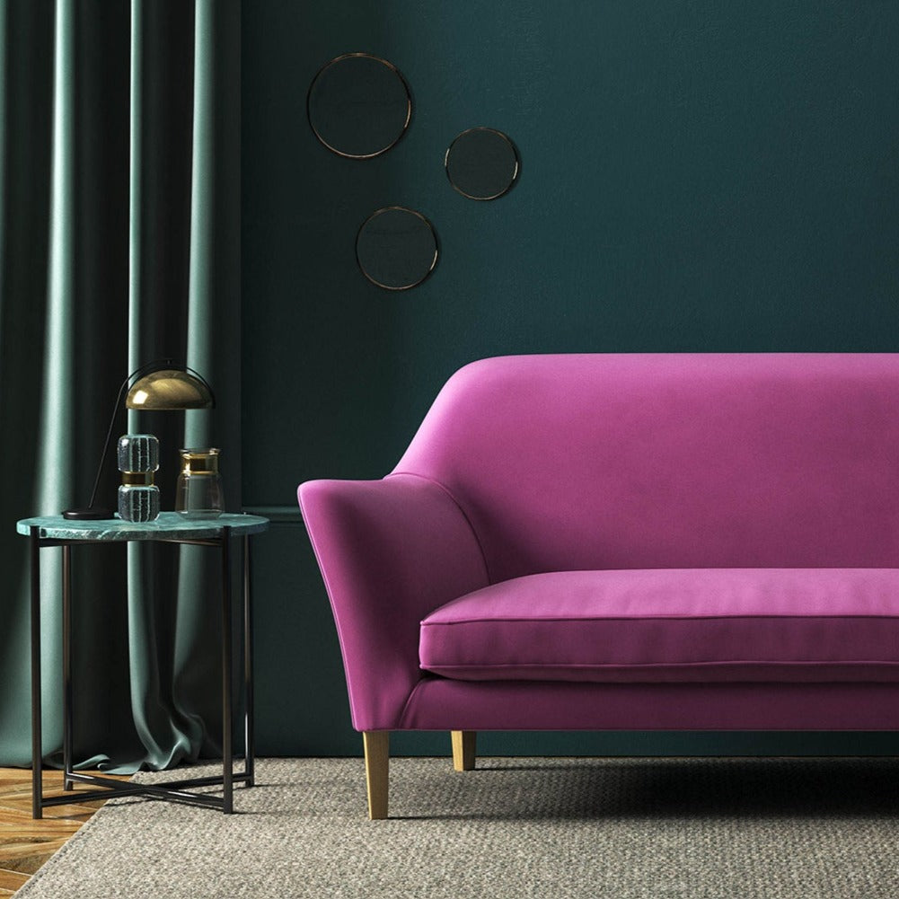 Sofa covered in a pink velvet upholstery fabric