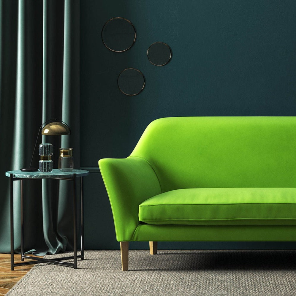 Sofa covered in a green velvet upholstery fabric