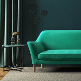 Sofa covered in a green velvet upholstery fabric