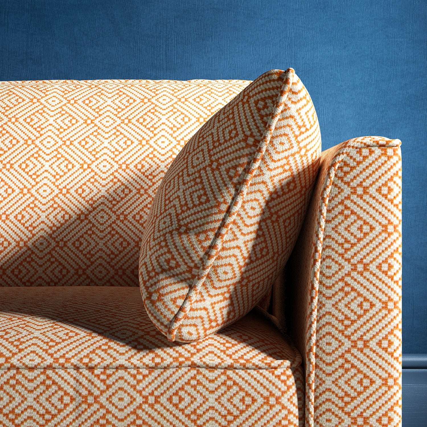 Sofa upholstered in a orange and neutral geometric weave upholstery fabric