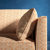 Sofa upholstered in a orange and neutral geometric weave upholstery fabric