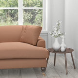 Sofa upholstered in a orange fabric with a light woven geometric design