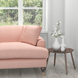 Sofa in a light pink upholstery fabric with a light neutral woven geometric design
