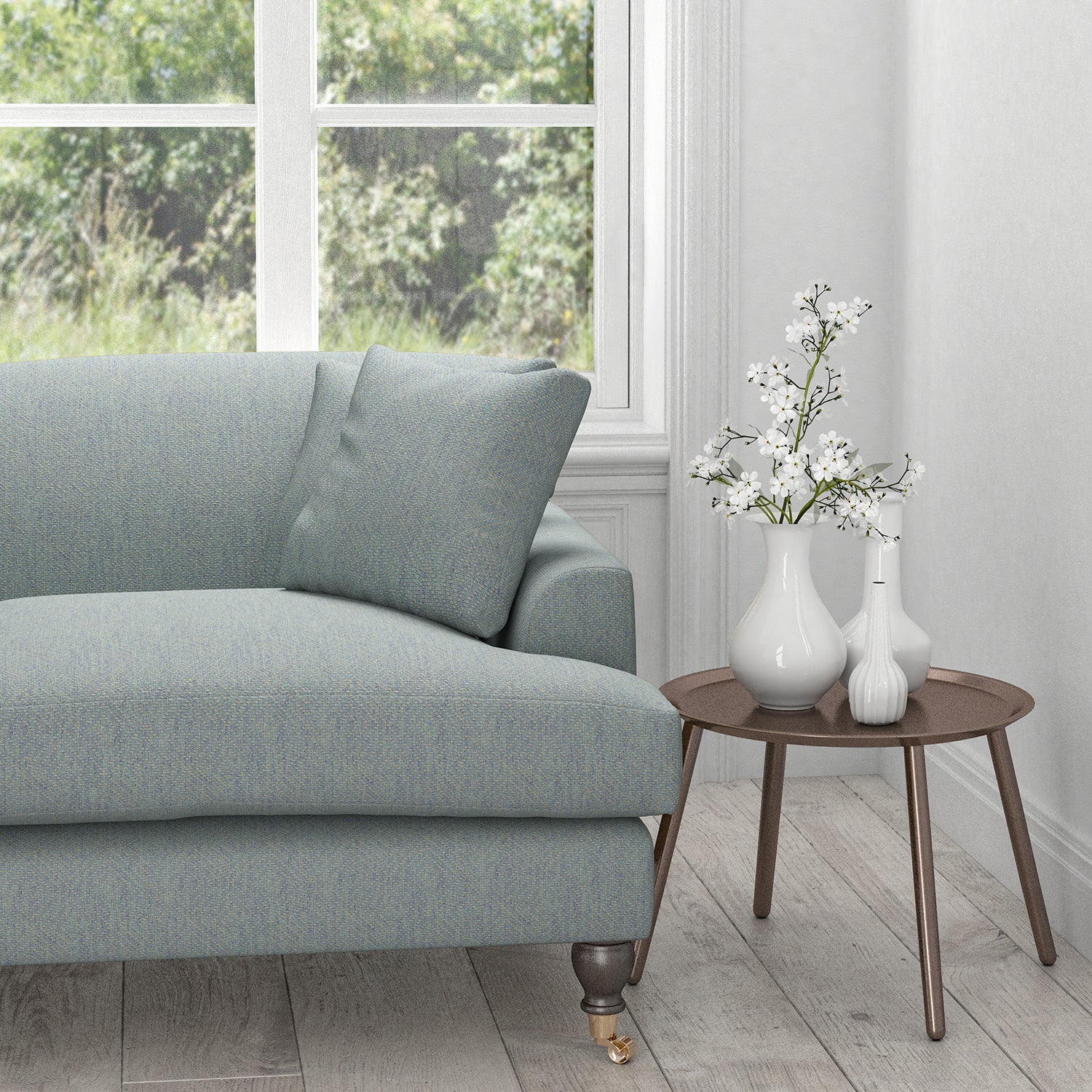 Sofa upholstered in a light blue fabric with a neutral woven design