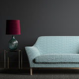Sofa upholstered in a blue and white wavy weave fabric.