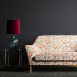 Orange and grey sofa in upholstered in a fabric with a tropical leaf design