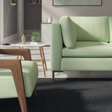 Living room with a contemporary sofa upholstered in a green semi-plain Scandi-style upholstery fabric