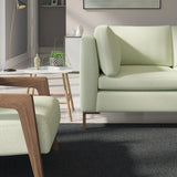 Living room with a contemporary sofa upholstered in a green semi-plain Scandi-style upholstery fabric