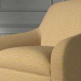 Close up of a chair covered in a woven fabric in a herringbone design in Marigold