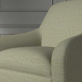 Close up of a chair covered in a woven fabric in a herringbone design in Fern
