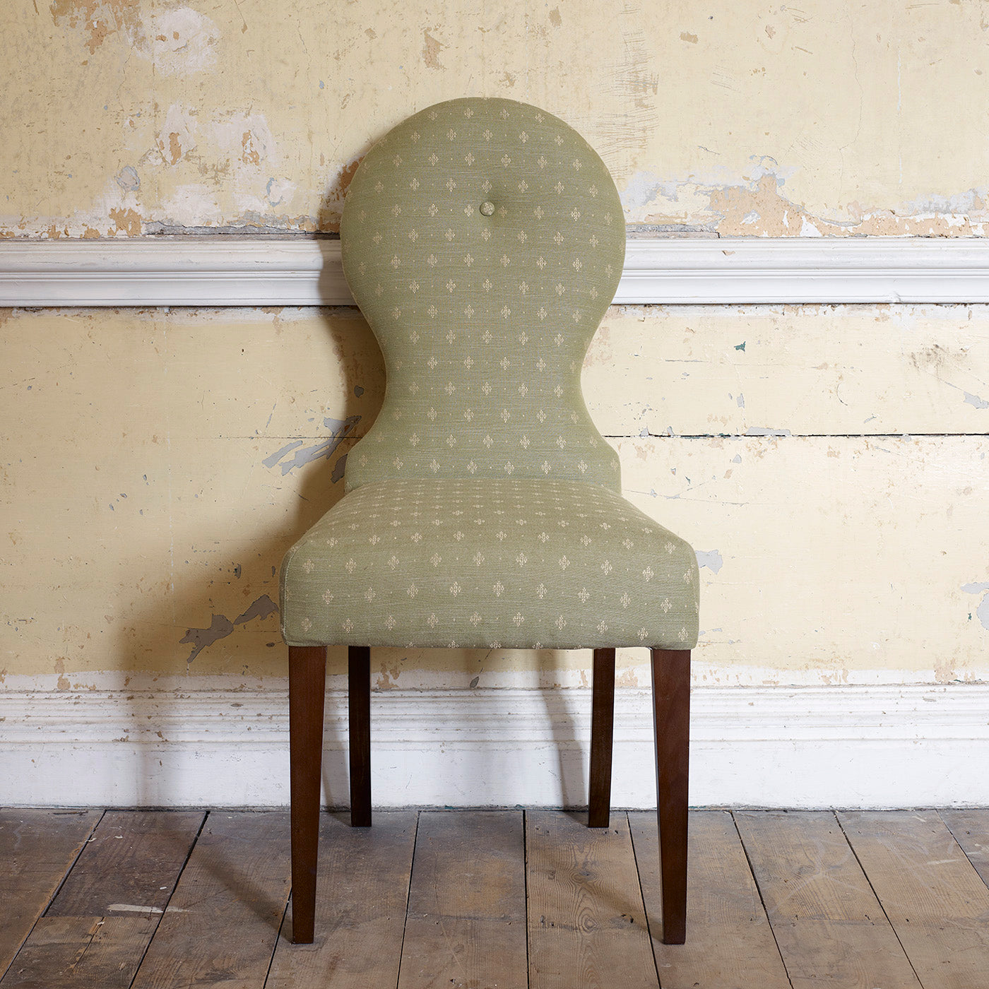 A green woven fabric on an armchair.