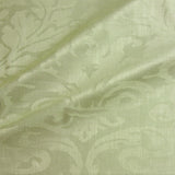 Fabric swatch of a contemporary damask fabric in a light green colour for upholstery and curtains.