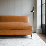 Orange velvet upholstery fabric on a classic sofa.