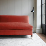 Orange velvet upholstery fabric on a classic sofa.