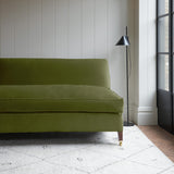Green velvet upholstery fabric on a classic sofa.
