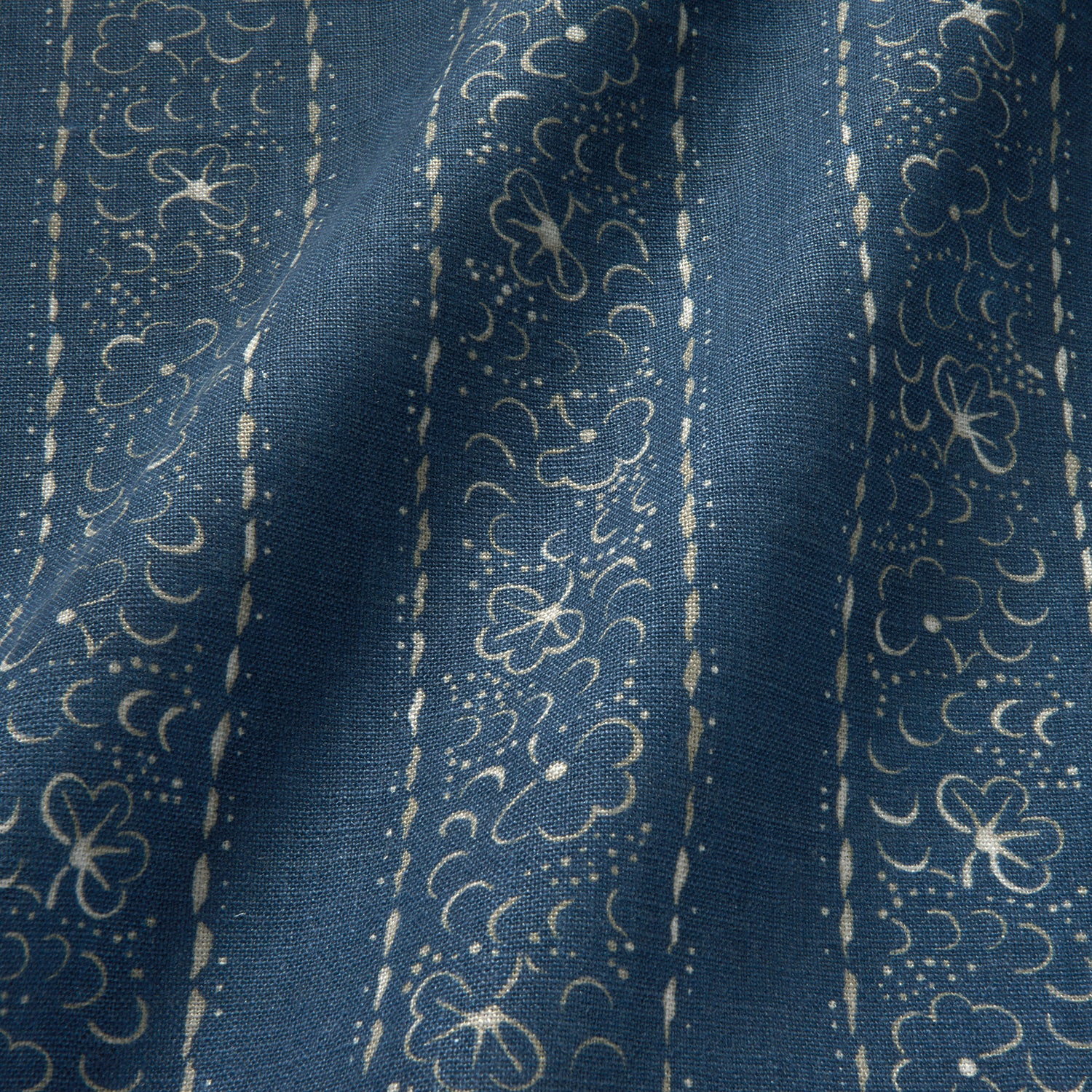 Printed linen fabric sample – a delicate pattern of moons and star-like dots in blue and cream