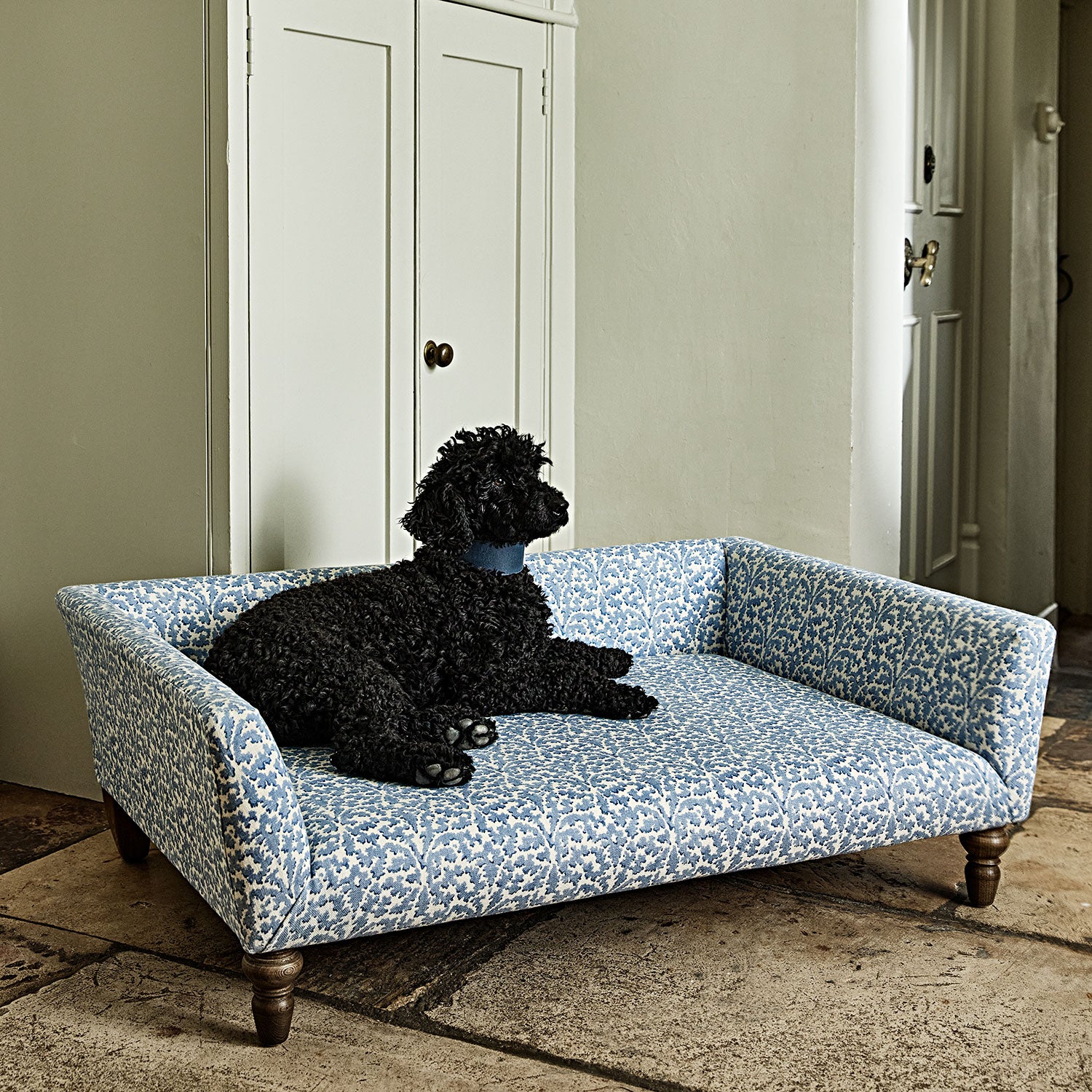 Printed linen fabric – damask-style pattern in blue and cream – on a dog bed, with dog.