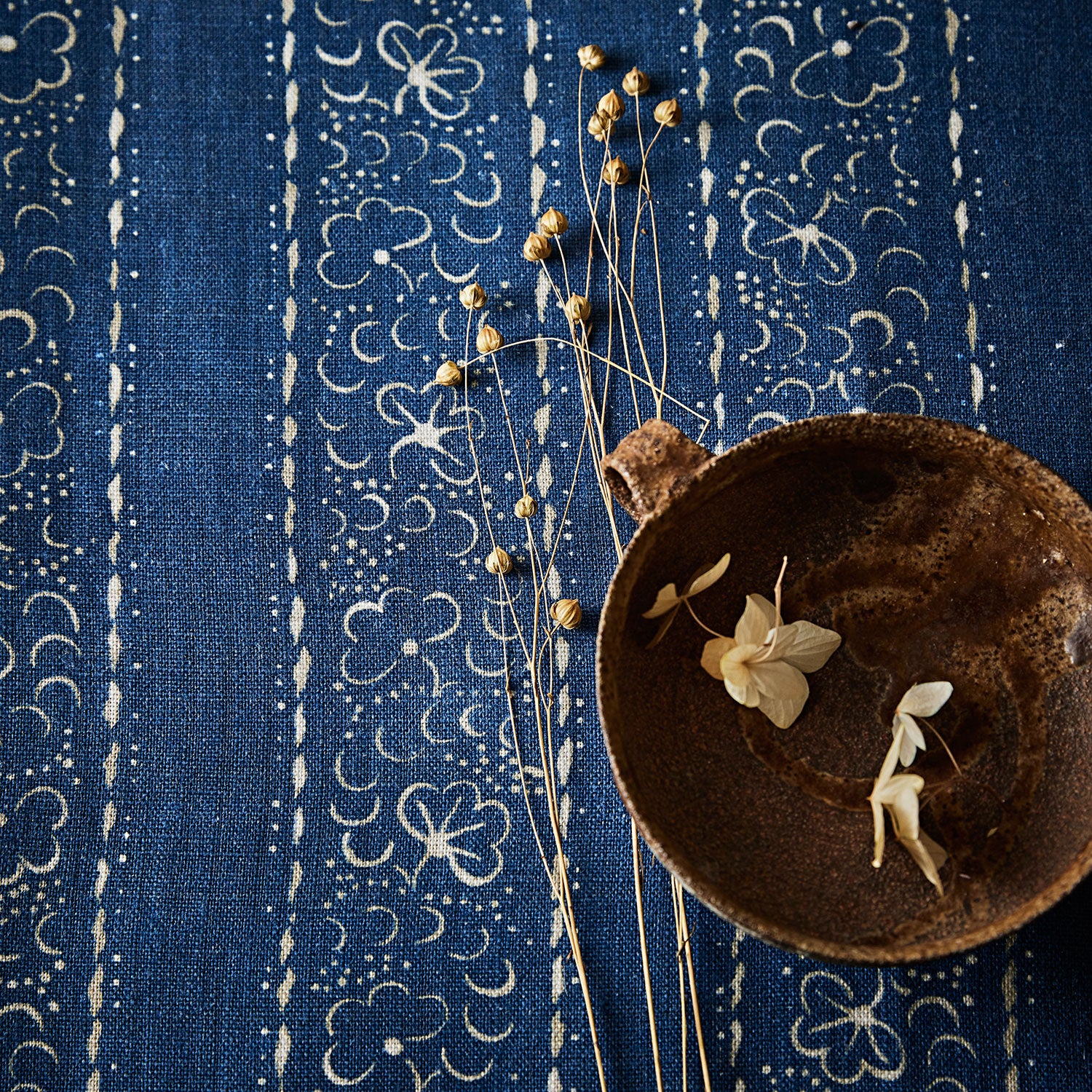 Printed linen fabric sample – a delicate pattern of moons and star-like dots in blue and cream