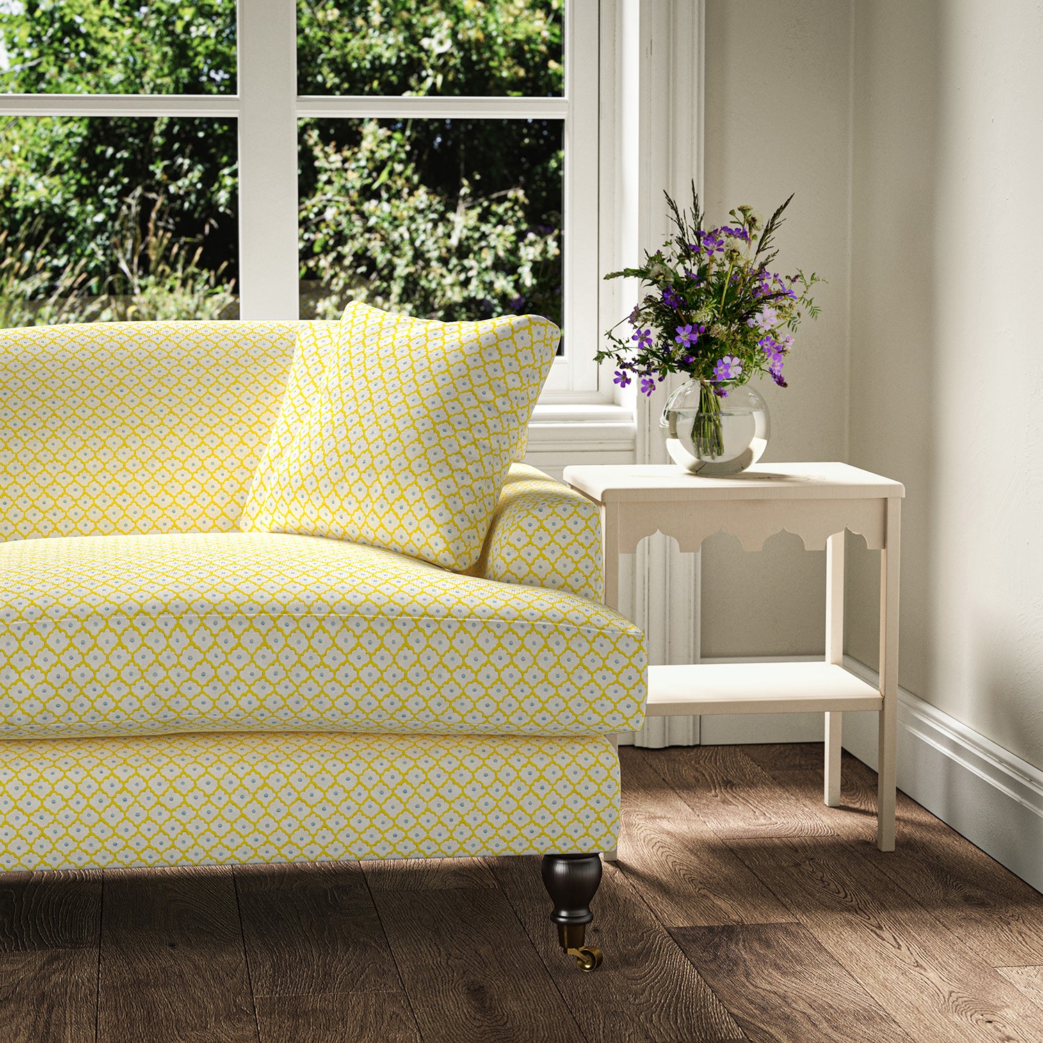 Printed linen fabric – a classic trellis design in blue, yellow, and cream – on a sofa