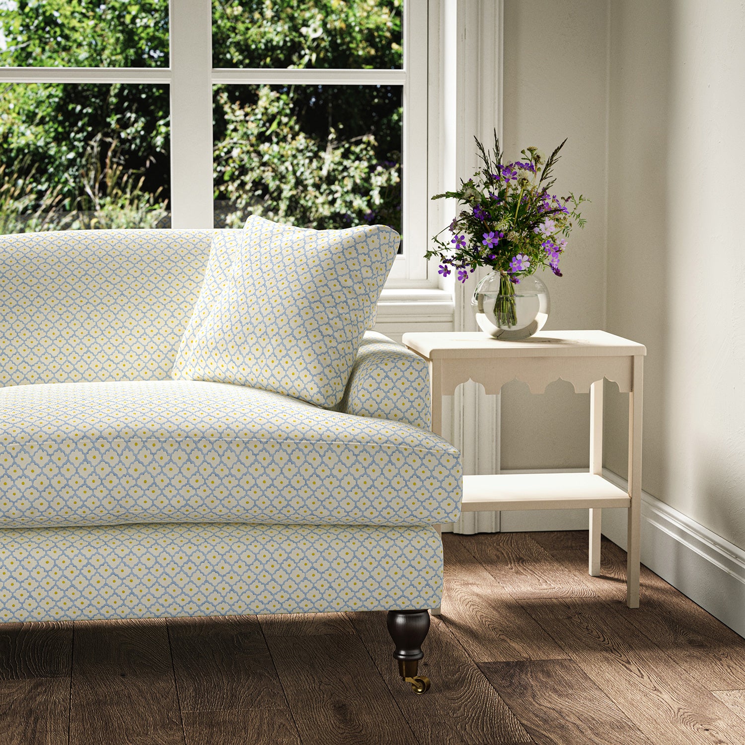 Printed linen fabric – a classic trellis design in blue, yellow, and cream – on a sofa