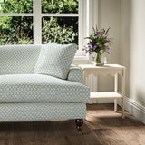 Printed linen fabric – a classic trellis design in blue, yellow, and cream – on a sofa