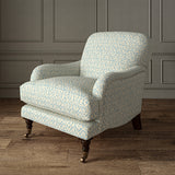 Printed linen fabric – a hand drawn; mirrored leaf motif pattern in blue and cream – on an armchair