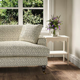 Printed linen fabric – a hand drawn; mirrored leaf motif pattern in blue and cream – on a sofa