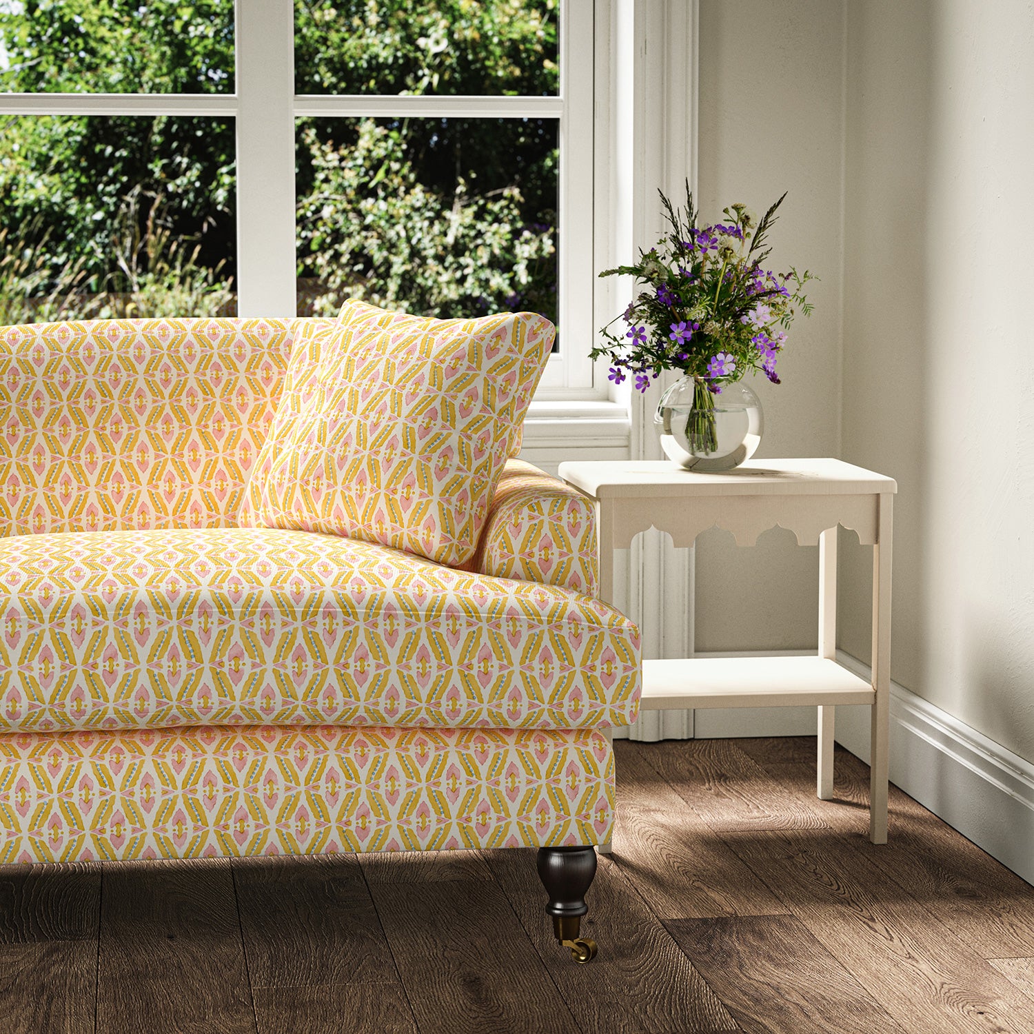 Printed linen fabric - a geometric design in pink, yellow and blue – on a sofa