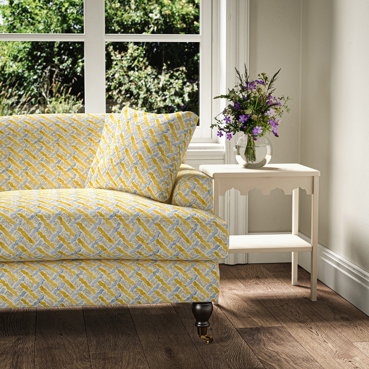 Printed linen fabric - a contemporary lattice design in yellow, blue, cream and white – on a sofa